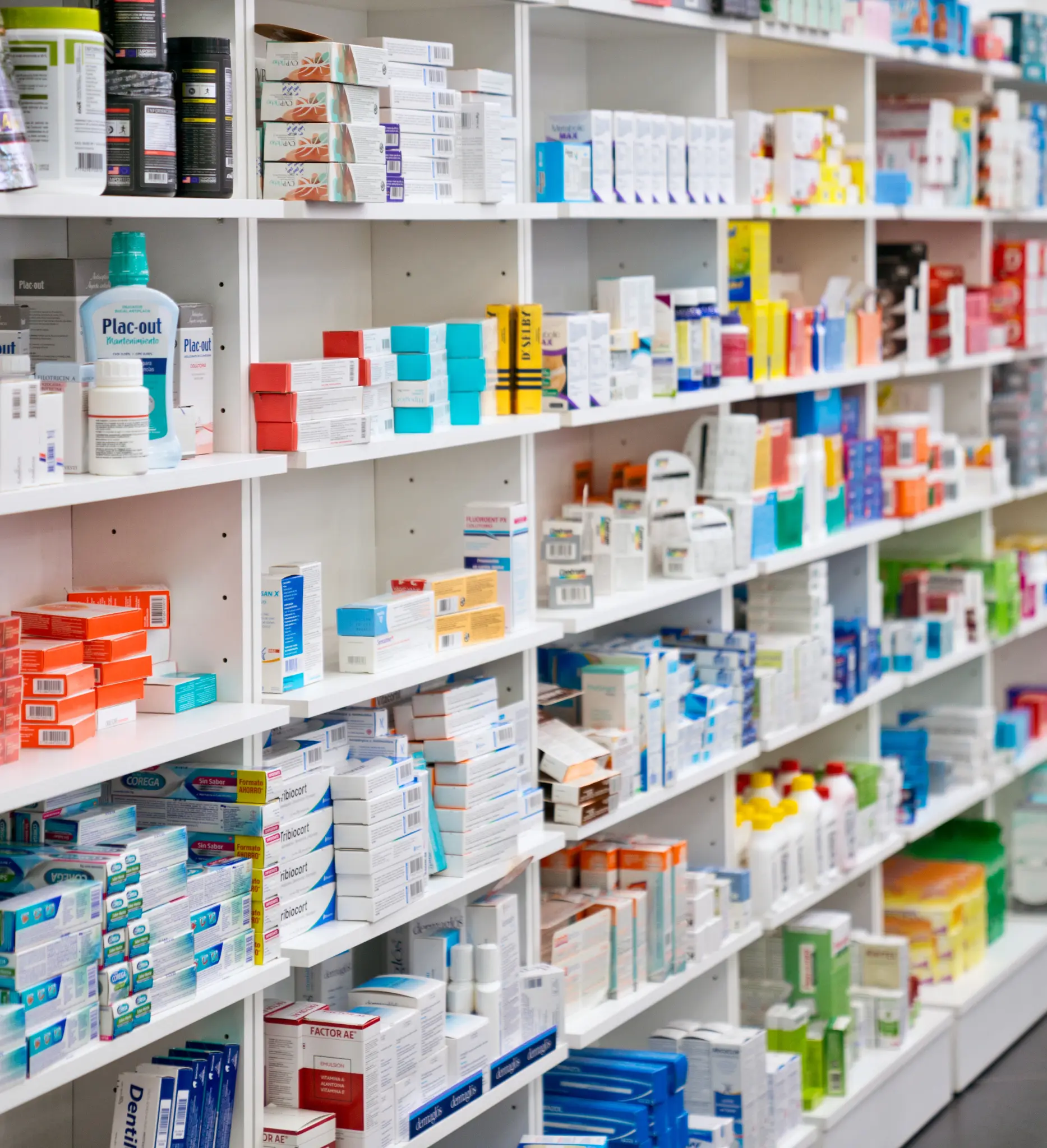 Fully stocked pharmacy shelves lined with boxed medicines and pharmacy products